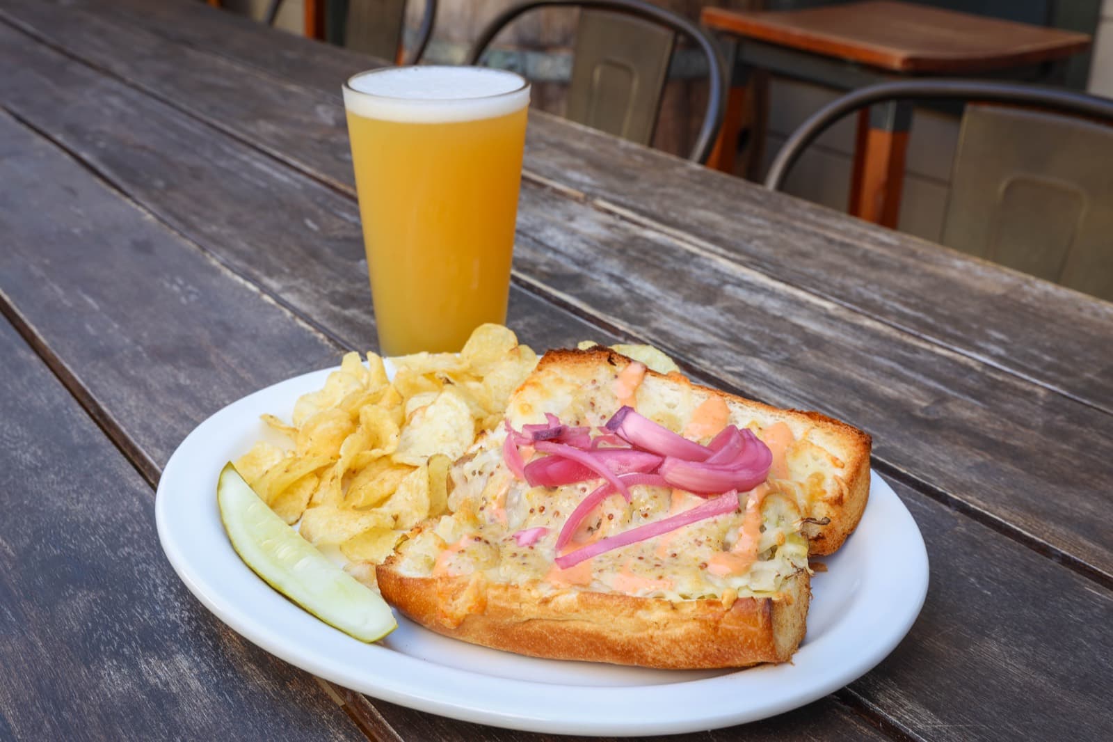 Banger on a bun with Swiss cheese and sauerkraut, served with kettle chips