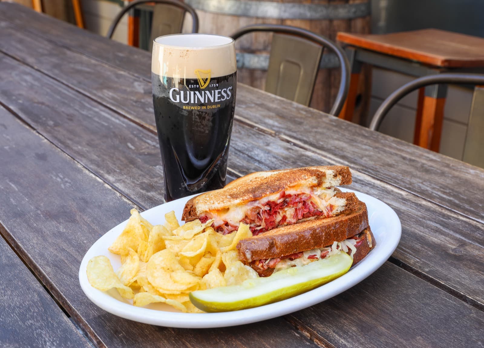 Reuben sandwich with chips and a pickle